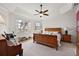 Main bedroom with wood furniture, ceiling fan, and golf course view at 2202 Blackville Dr, The Villages, FL 32162