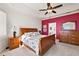 Bedroom with wood furniture, ceiling fan and accent wall at 2202 Blackville Dr, The Villages, FL 32162