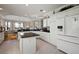 Bright kitchen with white cabinets, granite counters & breakfast bar at 2202 Blackville Dr, The Villages, FL 32162