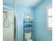 Clean bathroom with shower, toilet and shelving unit at 2219 Welcome Way, The Villages, FL 32162