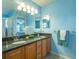 Double vanity bathroom with granite countertops and light blue walls at 2219 Welcome Way, The Villages, FL 32162