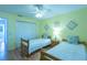 Bedroom with two twin beds, ceiling fan, and light wood flooring at 2219 Welcome Way, The Villages, FL 32162