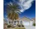 Tan house with white garage door and palm tree at 2219 Welcome Way, The Villages, FL 32162