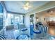 Sunroom dining area with glass table and blue striped chairs at 2219 Welcome Way, The Villages, FL 32162