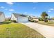 House exterior with a spacious driveway and well-manicured lawn at 2304 Jonebury Run, The Villages, FL 32162