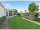 Landscaped backyard featuring a brick-lined pathway and a well-maintained lawn at 2338 Mcclellanville Ter, The Villages, FL 32162