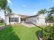 Single story home with white siding, attached garage, and palm trees at 2338 Mcclellanville Ter, The Villages, FL 32162