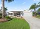 Single-story home with white siding, attached garage, and palm trees at 2338 Mcclellanville Ter, The Villages, FL 32162