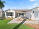 Single story home with white siding, attached garage and landscaped yard at 2338 Mcclellanville Ter, The Villages, FL 32162