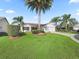 Single-story home with white siding, attached garage, and palm trees at 2338 Mcclellanville Ter, The Villages, FL 32162