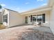 Brick paved porch with two chairs and entrance to single-story home at 2338 Mcclellanville Ter, The Villages, FL 32162