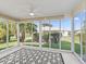 Spacious screened porch with patterned rug and backyard view at 2338 Mcclellanville Ter, The Villages, FL 32162