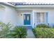 Front entrance with a teal door and lush landscaping at 2355 Lakeview Ave, Clermont, FL 34711