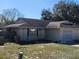 Low angle view of a single-story house featuring an attached garage and traditional architectural style at 2438 Centennial Blvd, Leesburg, FL 34748