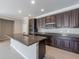 Modern kitchen features dark wood cabinets, granite countertops, and an island at 24506 Woodhill Ct, Sorrento, FL 32776