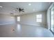 Spacious living room with tile floors, ceiling fan, and sliding glass doors at 24506 Woodhill Ct, Sorrento, FL 32776