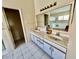 Primary bathroom with dual sinks and a large mirror at 24947 Cranes Roost Cir, Leesburg, FL 34748