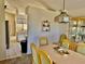 Dining room with light wood table and chairs and kitchen view at 24947 Cranes Roost Cir, Leesburg, FL 34748