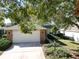 Front view of a single-story house with a white garage door and landscaping at 24947 Cranes Roost Cir, Leesburg, FL 34748