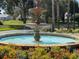 Ornate fountain with colorful flowers in a community at 24947 Cranes Roost Cir, Leesburg, FL 34748