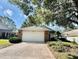 House front with brick facade and attached garage at 24947 Cranes Roost Cir, Leesburg, FL 34748