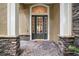 Welcoming front entry with stone accents and a charming door at 25833 Feather Ridge Ln, Sorrento, FL 32776