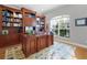 Spacious home office with built-in wooden cabinetry and large window at 25833 Feather Ridge Ln, Sorrento, FL 32776