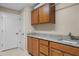 Laundry room with wooden cabinets, granite countertop and sink at 25833 Feather Ridge Ln, Sorrento, FL 32776