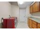 Bright laundry room, features washer, dryer, cabinets, granite countertop at 25833 Feather Ridge Ln, Sorrento, FL 32776