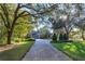 Circular driveway showcasing a home with lush landscaping and large trees at 2614 W Ponkan Rd, Apopka, FL 32712