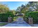 Brick pillars and iron gate open to a paved driveway at 2614 W Ponkan Rd, Apopka, FL 32712