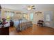 Bright bedroom featuring a king-size bed and wood floors at 26409 Evert St, Leesburg, FL 34748