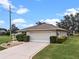 Single-story home with a two-car garage and neatly trimmed shrubs at 26409 Evert St, Leesburg, FL 34748