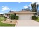 Single-story home with a two-car garage and well-manicured lawn at 26409 Evert St, Leesburg, FL 34748