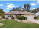 Landscaped yard surrounds this single-story house with a garage at 26409 Evert St, Leesburg, FL 34748