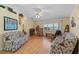 Living room with hardwood floors, comfy seating, and a ceiling fan at 26409 Evert St, Leesburg, FL 34748