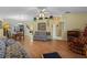 Bright living room featuring hardwood floors, floral sofas, and a ceiling fan at 26409 Evert St, Leesburg, FL 34748