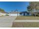 Newly painted house with a spacious yard, basketball hoop, and a long driveway at 2715 N Dellwood Dr, Eustis, FL 32726