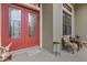 Inviting entryway with a striking red double door and cozy seating area at 27238 Stoney Brook Dr, Leesburg, FL 34748