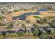 Aerial view of houses, golf course, and pond at 276 Lawthorn St, The Villages, FL 32162