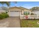 Charming home exterior with two-car garage, flower beds, and a white picket fence at 2821 Barboza Dr, The Villages, FL 32162