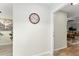 Open-concept interior showcasing wood-look flooring and a clock in the hallway at 2821 Barboza Dr, The Villages, FL 32162