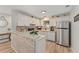 Bright kitchen featuring white cabinets, a stainless steel refrigerator, and modern countertops at 2821 Barboza Dr, The Villages, FL 32162