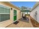 Side patio with an outdoor seating area, green door, and outdoor rug for relaxing at 2821 Barboza Dr, The Villages, FL 32162