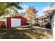 Red metal storage shed with a white garage door at 3336 Florene Dr, Orlando, FL 32806