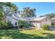 Front yard view of charming brick ranch home with well-manicured lawn at 36703 Sandy Ln, Grand Island, FL 32735