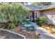 Charming home entrance featuring a brick facade, well-manicured landscaping, and cozy outdoor seating area at 36703 Sandy Ln, Grand Island, FL 32735