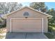 Attached garage with tan door and brick exterior at 36703 Sandy Ln, Grand Island, FL 32735