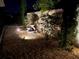 Landscaped backyard with fountain at night at 4063 Deskin Ln, The Villages, FL 32163