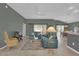 Living room with teal sofas, coffee table, and view into kitchen at 4063 Deskin Ln, The Villages, FL 32163